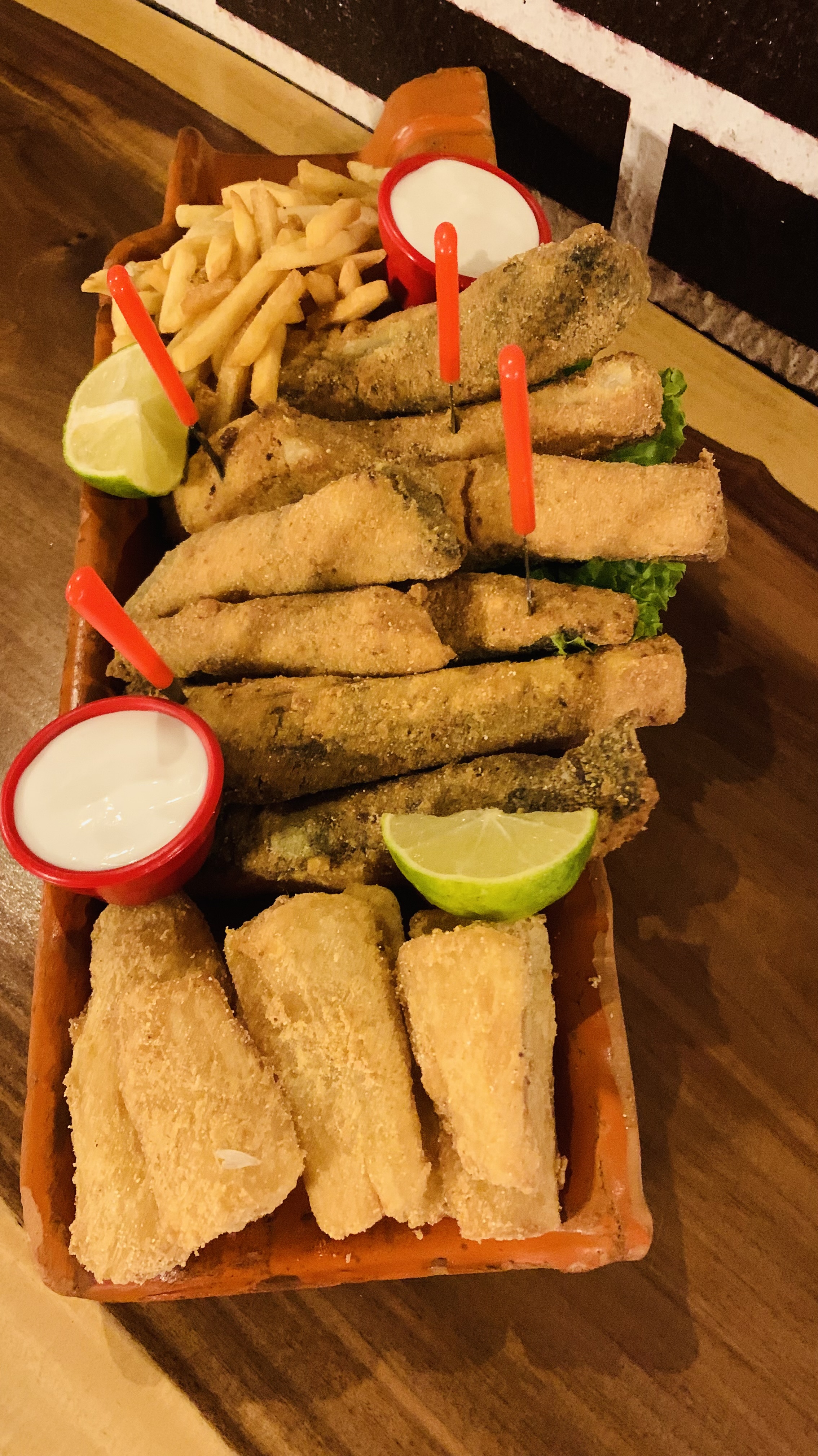 Peixe frito com acompanhamentos e molhos